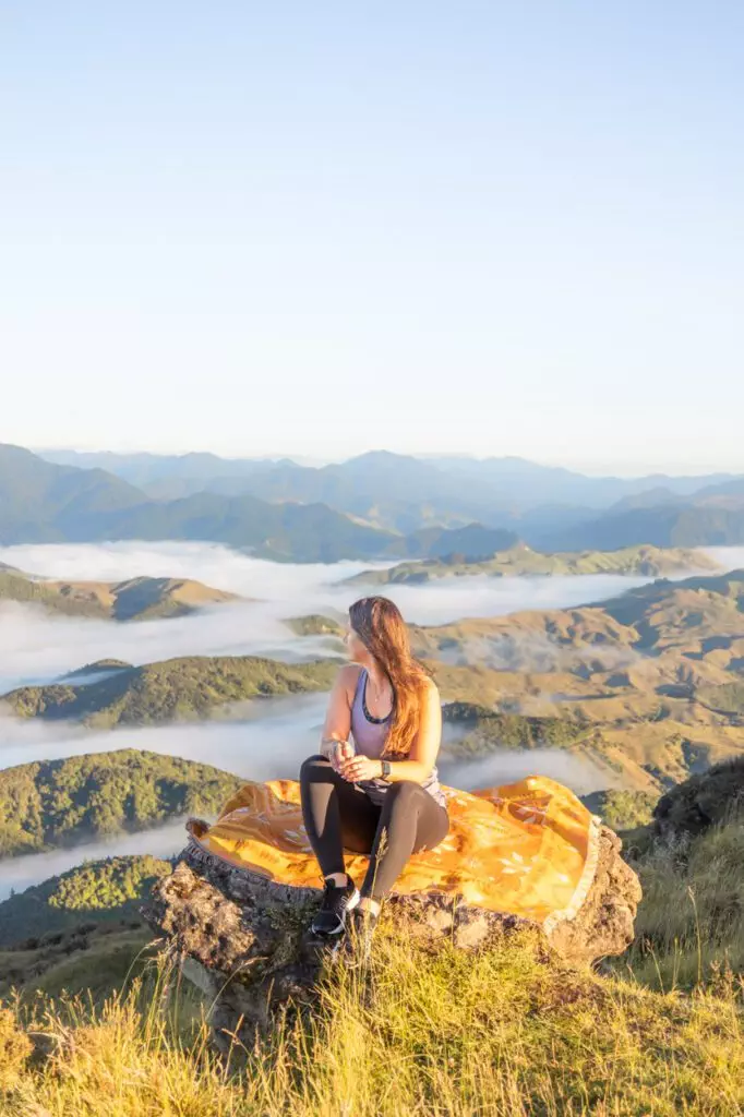 girl sitting on throw overlooking landscape